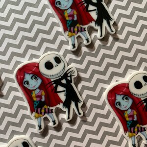 Puede incluir: Una imagen de primer plano de dos personajes de dibujos animados, Jack Skellington y Sally de Pesadilla antes de Navidad. Jack lleva su traje negro caracter&iacute;stico y tiene una amplia sonrisa, mientras que Sally lleva su vestido de retazos y tiene una expresi&oacute;n dulce. Los personajes est&aacute;n de pie uno al lado del otro, con el brazo de Jack alrededor de la cintura de Sally.