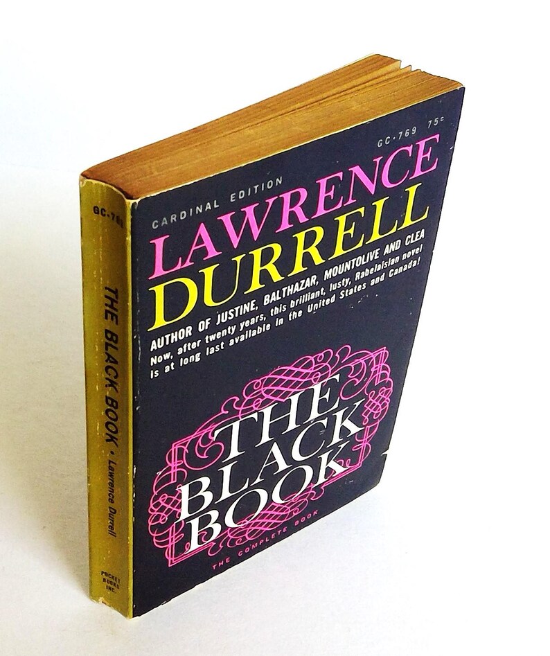 May include: A vintage paperback book titled "The Black Book" by Lawrence Durrell. The cover is black with pink and white text, and the edges of the pages are gold. The book is a Cardinal Edition.