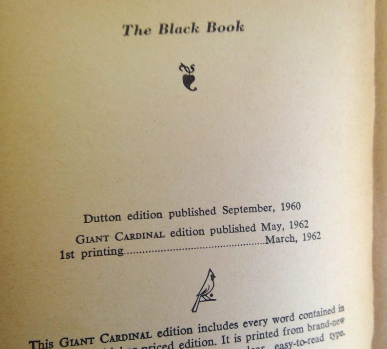 May include: An open book page with the title "The Black Book" at the top. Below the title are details about the Dutton and Giant Cardinal editions, including publication dates of 1960 and 1962. The page has a vintage, aged appearance.