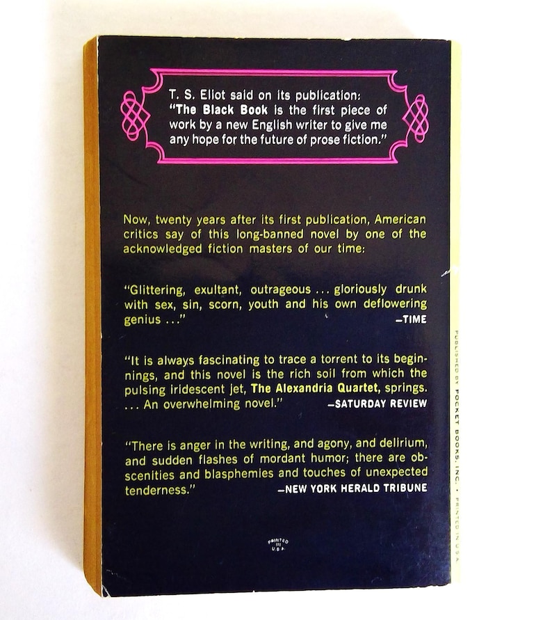 May include: The back cover of a vintage paperback book titled "The Black Book." The cover is black with white text and pink decorative elements. Quotes from critics and T.S. Eliot are featured.