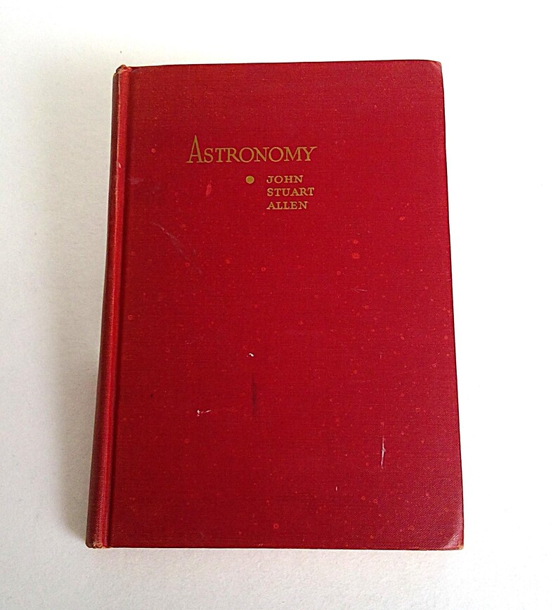 Puede incluir: Un libro rojo de tapa dura titulado "Astronomy" con letras doradas. El nombre del autor, John Stuart Allen, tambi&eacute;n est&aacute; en dorado. El libro est&aacute; cerrado y parece estar en buen estado, con el lomo ligeramente desgastado.