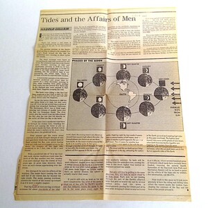 Puede incluir: Un art&iacute;culo de peri&oacute;dico vintage titulado "Tides and the Affairs of Men" con texto y diagramas sobre las fases de la luna y su efecto en las mareas. El papel est&aacute; amarillento y doblado.