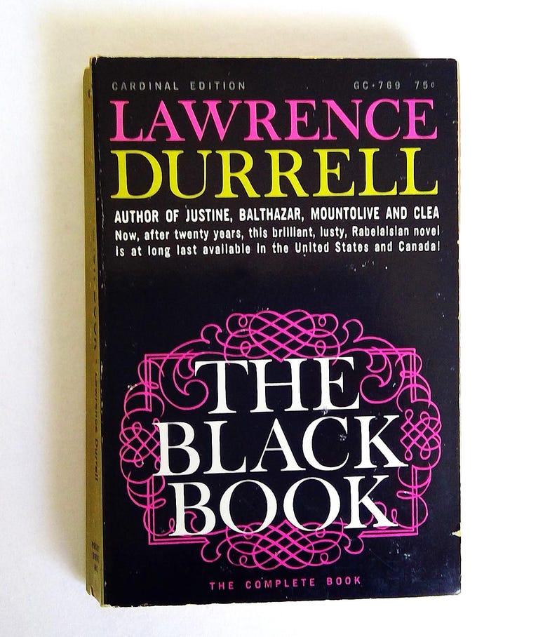 May include: A vintage paperback book titled "The Black Book" by Lawrence Durrell. The cover is black with pink and yellow text. The book is a Cardinal Edition and includes the text "The Complete Book".