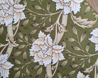 May include: Green fabric with a repeating pattern of white and gold flowers and leaves.