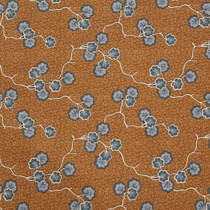 Peut inclure: Un tissu brun avec un motif répétitif de petites branches fleuries bleues. Les branches sont composées de cinq petites feuilles arrondies avec des contours blancs.