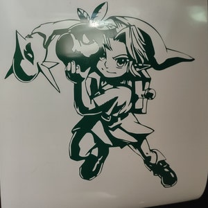 May include: A green vinyl decal of a cartoon character holding a bomb. The character is wearing a green hat and a green tunic. The character is in a fighting pose.
