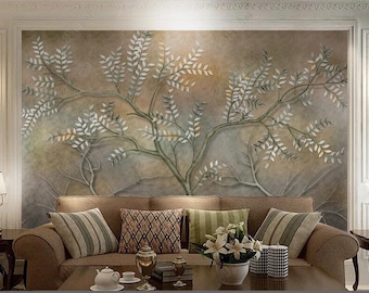 May include: A living room interior with a brown sofa and throw pillows. The wall behind the sofa features a large-scale mural of a stylized tree with white leaves on a brown background.
