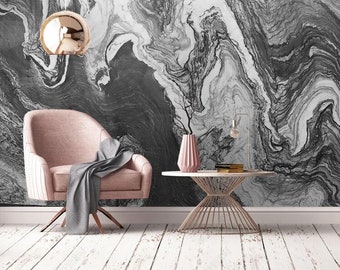 May include: A contemporary interior scene with a pink armchair and a grey throw, a small round table, and a decorative vase. The backdrop is a marble-effect wall in grey and white, with a gold pendant light.