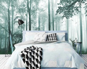 Könnte beinhalten: Ein weißes Bett mit einer schwarz-weißen gemusterten Decke und Kissen. Das Bett steht vor einer Wand mit einer Waldtapeten. Die Tapete ist hellgrün und zeigt Bäume, Vögel und ein Reh.