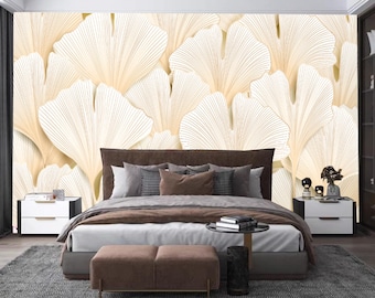 Könnte beinhalten: Ein braunes, gepolstertes Bett mit weißer Bettwäsche und zwei weißen Nachttischen. Die Wand hinter dem Bett ist mit einer großflächigen Tapete mit einem Muster aus weißen und goldenen Ginkgoblättern verziert.