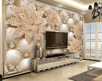 May include: A living room interior design with a large flat screen TV mounted on a wall with a decorative wallpaper featuring a gold and white floral pattern. The wallpaper has a quilted texture and features large, ornate flowers with a diamond-like design.