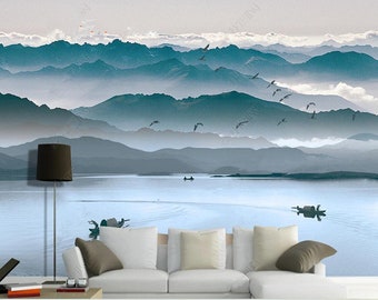 May include: A watercolor painting of a misty mountain landscape with a lake in the foreground. The mountains are a soft blue-green color, and the lake is a light blue. There are birds flying in the sky.