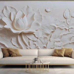 Peut inclure: Une murale murale 3D blanche avec une grande fleur de lotus et des feuilles. La murale est affichée derrière un canapé blanc avec des coussins de couleur marron.
