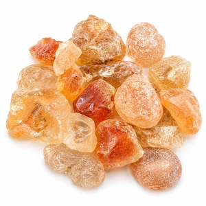 May include: A collection of amber-colored, irregularly shaped pieces, possibly gemstones or crystals, against a white background. The pieces vary in size and have a translucent quality, with some displaying a deeper, reddish-brown hue.