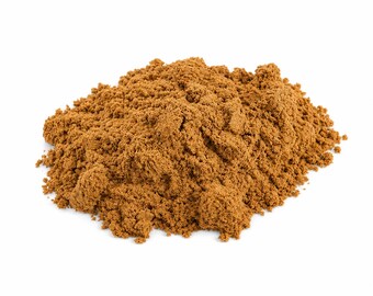 May include: A mound of light brown powder, likely a spice, against a white backdrop. The powder has a fine, granular texture, with visible variations in tone. The image is well-lit, showing the details of the powder's texture and colour.