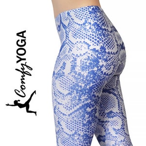 Op de afbeelding: Blauw en witte yoga legging met slangenprint. De legging is nauwsluitend en heeft een gedetailleerd patroon. De merknaam "Comfy Yoga" wordt in cursief weergegeven met een yoga pose afbeelding.