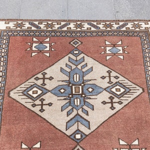 May include: A red, white, and blue patterned rug with a geometric design. The rug has a border with a repeating pattern of stars and diamonds.
