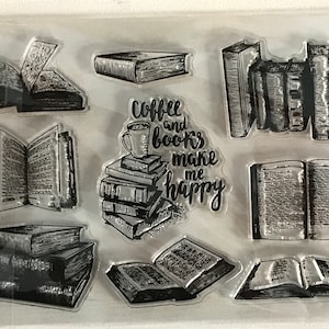 Könnte beinhalten: Eine transparente Blatt mit Stempeln mit Bildern von Büchern und Kaffee. Die Stempel zeigen den Text "Coffee and books make me happy".
