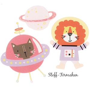 Könnte beinhalten: Ein Set aus drei Filz-Applikationen mit einem rosa Planeten mit Ring, einem Löwen in einem lila Astronautenanzug und einer Katze in einem rosa Raumschiff. Der Text "Stoff-Förmchen" ist unter den Formen gedruckt.