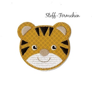 Könnte beinhalten: Eine gestickte Tigerkopf-Applikation in Gelb und Schwarz mit dem Text "Stoff-Förmchen".