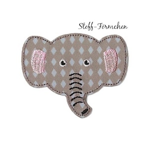 Könnte beinhalten: Ein Stoff-Applikation in Form eines Elefanten mit einem Rautenmuster in Grau- und Beigetönen. Der Elefant hat rosa gestickte Ohren und einen Rüssel. Der Text "Stoff-Förmchen" befindet sich über dem Elefanten.