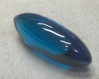 May include: A smooth, teardrop-shaped, blue glass bead with a glossy finish.