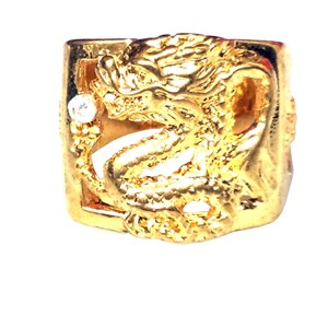 Könnte beinhalten: Goldring mit einem detaillierten Drachenmotiv und einem kleinen, klaren Stein.