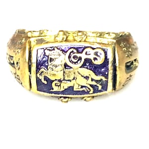 May include: A gold ring with a purple enamel inlay featuring a stylized horse design. The ring has intricate details and a textured band.