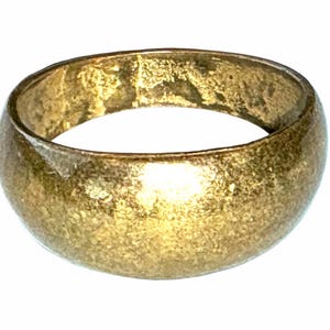 Op de afbeelding: Een goudkleurige bandring met een glad, afgerond buitenoppervlak en een gepolijste afwerking. De ring heeft een consistente breedte over het gehele cirkelvormige ontwerp en toont een metalen textuur met subtiele variaties in lichtreflectie.