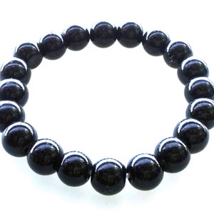 May include: A black beaded bracelet with round, smooth beads.