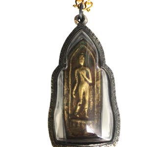 Può includere: Un ciondolo d'oro con un'immagine di Buddha all'interno di una custodia in vetro trasparente. Il ciondolo è attaccato a una catena d'oro.