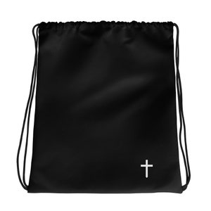 May include: Black drawstring bag with a white cross symbol on the lower right. The bag has black drawstrings and a simple, minimalist design. The bag is made of a smooth, matte material.