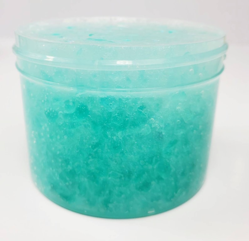 May include: A clear plastic jar filled with a light blue, sparkly slime.