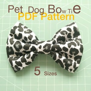 Puede incluir: Una pajarita de estampado de leopardo blanco y negro para mascotas. La pajarita está hecha de tela y tiene un diseño sencillo. El texto "Pet Dog Bow Tie PDF Pattern" y "5 Sizes" está impreso en la imagen.