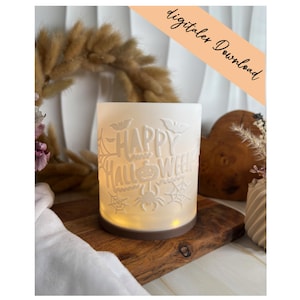 Könnte beinhalten: Ein zylindrisches, weißes, mattiertes Windlicht mit geprägten Halloween-Motiven wie Fledermäusen, Spinnennetzen, einer Spinne und einem Kürbis. Der Schriftzug "HAPPY HALLOWEEN" ist mittig platziert. Der braune Boden strahlt ein warmes Licht aus.