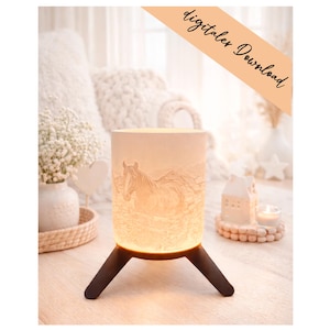 May include: A cylindrical, cream-colored lamp with a horse relief design, resting on a dark brown tripod base. The lamp is illuminated from within, casting a warm glow. The words "digitalex Download" are written on a diagonal banner.