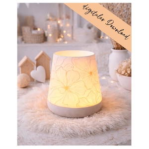 Op de afbeelding: Een crèmekleurige keramische lamp met een bloemenpatroon, die een warme gloed uitstraalt. Hij staat op een zachte, witte vloerbedekking. De tekst "digitaler Download" is zichtbaar. De lamp geeft zacht, sfeervol licht.