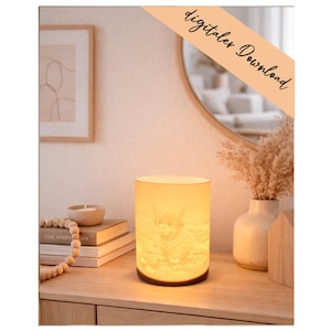 Peut inclure: Lampe cylindrique avec un motif de vache des Highlands, dégageant une lumière chaude. Le texte "digitaler Download" est visible. La lampe est posée sur une surface en bois. Le design de la lampe est gravé.