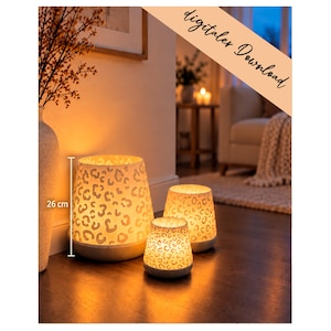 Può includere: Tre portacandele cilindrici con esterno bianco caratterizzato da un motivo leopardato intagliato che si illumina dall'interno. Il supporto più grande è contrassegnato da un'altezza di 26 cm. Il set include tre contenitori luminosi di dimensioni variabili.