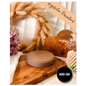 May include: A round, light brown object with a textured edge sits on a wooden cutting board. The image includes a dried floral wreath, a wooden heart, and the text "digitales Download" and "ADD-ON".