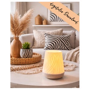 Könnte beinhalten: Eine beleuchtete, cremefarbene Keramiklampe mit Holzmaserung steht auf einem runden, hellen Tisch. Die Lampe befindet sich vor einem Sofa mit dekorativen Kissen und einem geflochtenen Tablett mit einer Vase und einer kleinen Topfpflanze. Der Text "digitalex Download" befindet sich oben rechts.