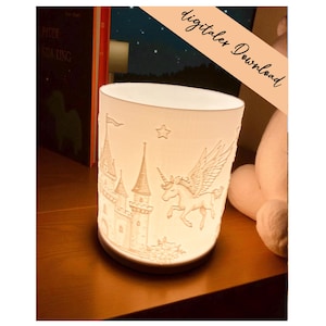 May include: A white ceramic candle holder with a castle and winged unicorn design. The holder has a cylindrical shape and is illuminated from within, creating a soft glow. The text "digitaler Download" is visible on the image.