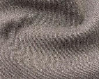 May include: A close-up of a brown fabric with a subtle texture. The fabric is smooth and has a slight sheen.