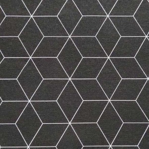 Op de afbeelding: Zwart-wit geometrische stof met een herhalend patroon van witte lijnen die kubussen vormen. Een liniaal is onderaan de afbeelding geplaatst met de nummers 1 tot en met 23.