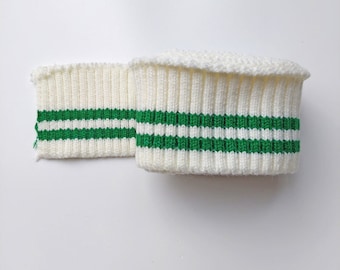 May include: White ribbed knit fabric with two green stripes. This fabric is commonly used for making cuffs or trim.