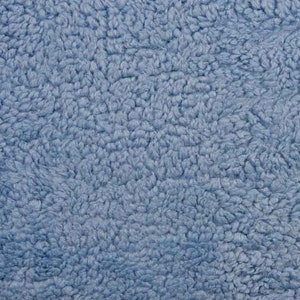 Könnte beinhalten: Nahaufnahme eines weichen, blauen, flauschigen Stoffes. Der Stoff hat eine strukturierte, flauschige Oberfläche.