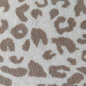 Könnte beinhalten: Nahaufnahme eines strukturierten Stoffes mit Leopardenmuster. Der Hintergrund ist cremeweiß, die Flecken sind warmbraun. Der Stoff hat ein weiches, plüschiges Aussehen.
