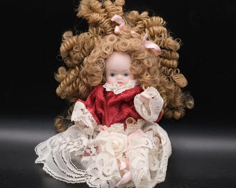 Muñeca de cerámica vintage con cara: cabello rubio y vestido rojo