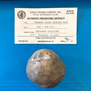 May include: An authentic prehistoric artifact, a Poverty Point cooking ball, with a diameter of 2.75 inches. The artifact is from Northern Louisiana and dates from 600-800 B.C. A museum file card is visible in the image.