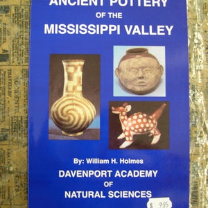 May include: A blue book cover with the title "Ancient Pottery of the Mississippi Valley" by William H. Holmes. The cover features three images of pottery: a brown and white pot with a spiral design, a brown pot with a human face, and a red and white pot shaped like a deer.